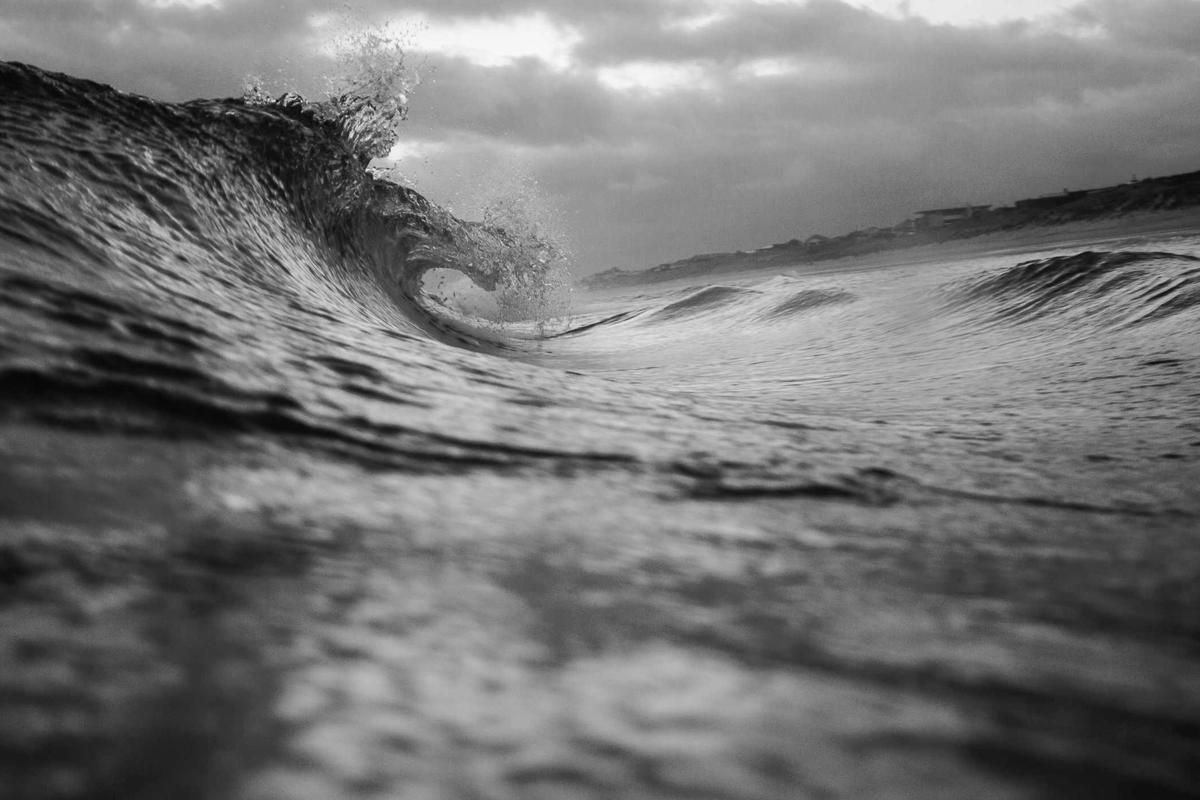 A wave curling toward shore, caught mid-break