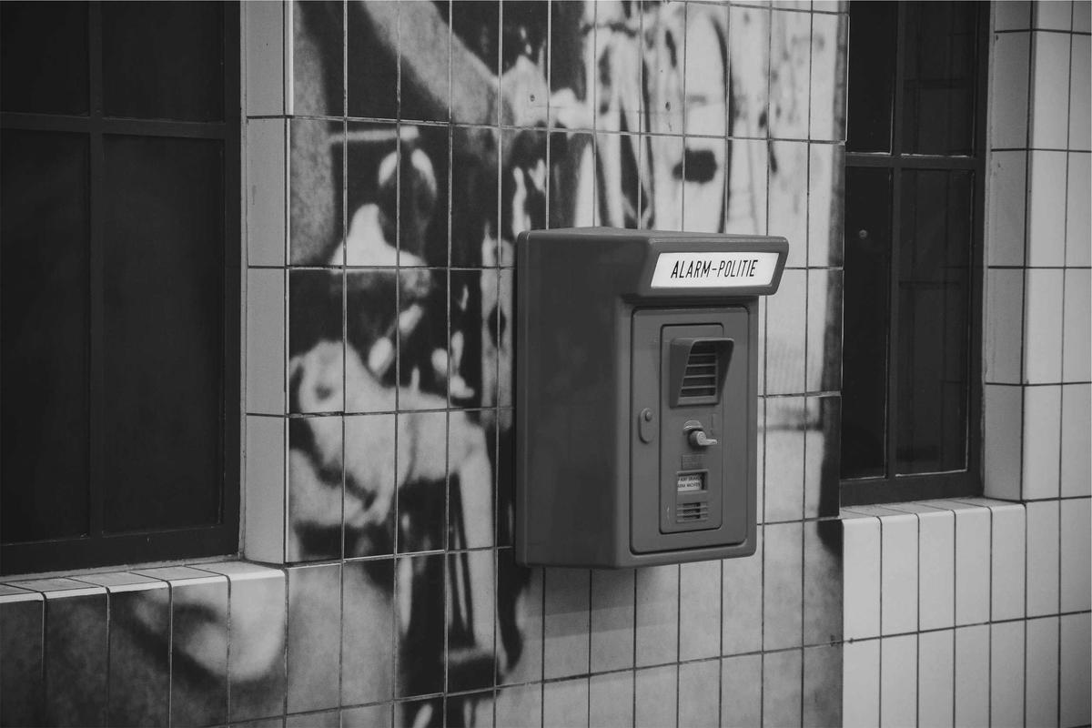 A vintage call box mounted on a tiled wall