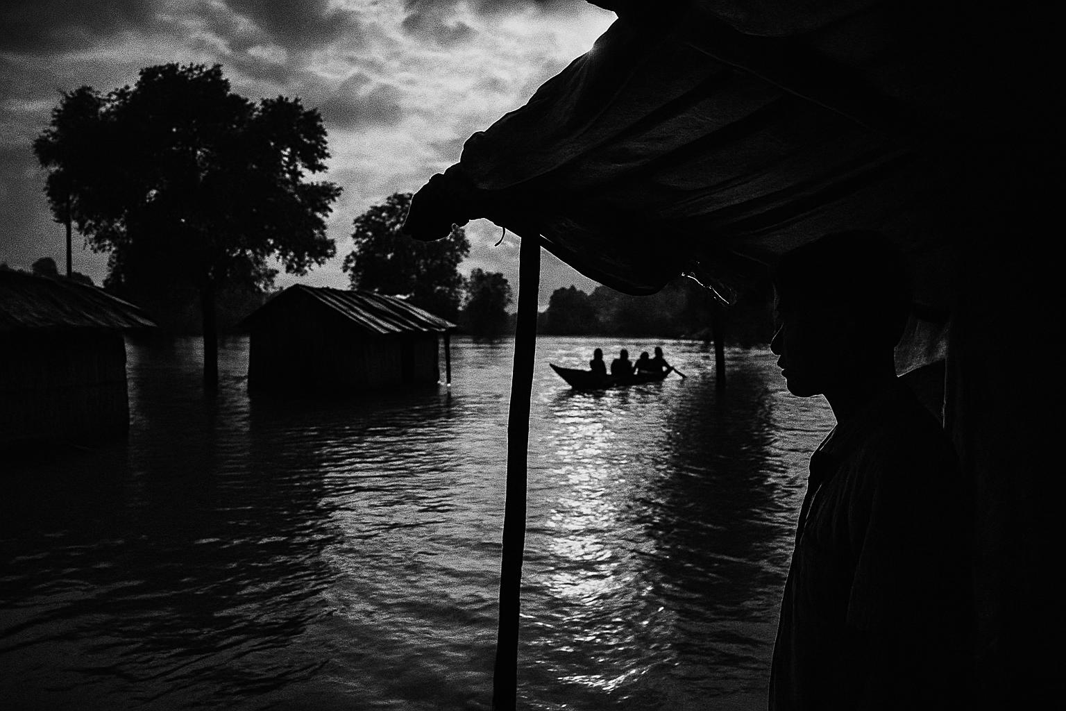 Grayscale editorial illustration: Assam’s Flood Ledger: 47 Dead, Over 6.5 Lakh Affected Across 11 Districts